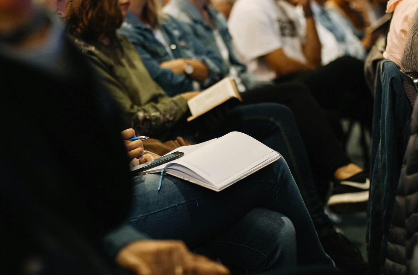 A warm, full seminar room of people listening and engaged